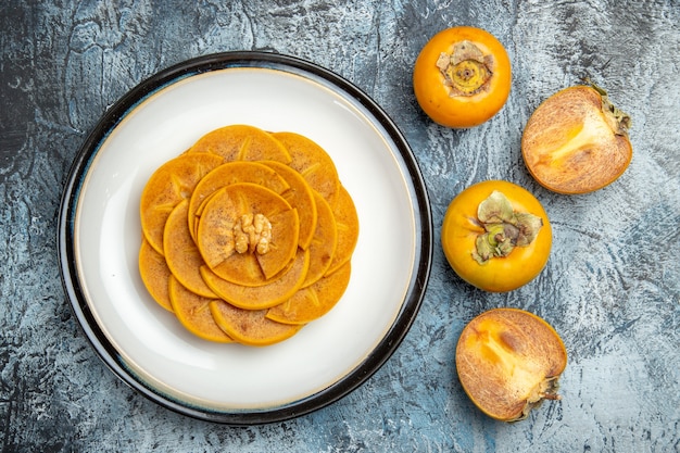 Top view of sliced persimmon on pancake on light surface