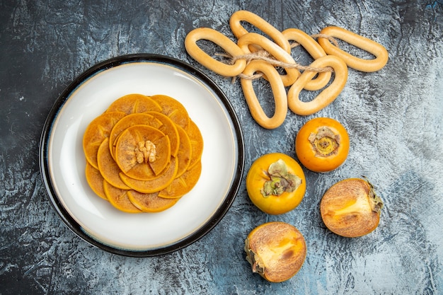 Free photo top view of sliced persimmon on pancake on light surface