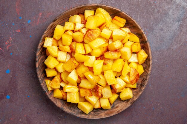 Top view sliced potatoes inside brown plate on dark