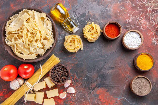 Top view sliced raw dough with seasonings on dark floor pasta dough dark food