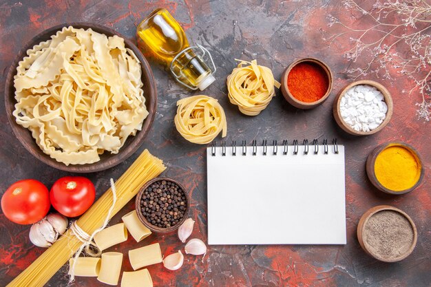 Top view sliced raw dough with seasonings on dark surface pasta dough food