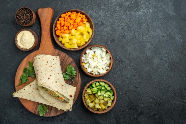 Top view sliced shaurma tasty salad sandwich with vegetables on grey surface burger pita sandwich salad bread