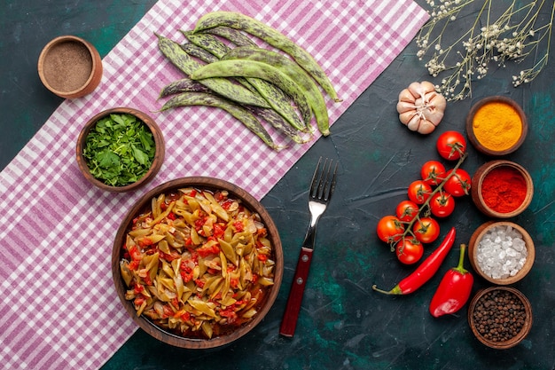 Top view sliced vegetable meal delicious beans meal with different seasonings on the blue desk