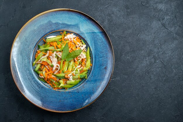 Top view sliced vegetable salad inside plate on dark grey background