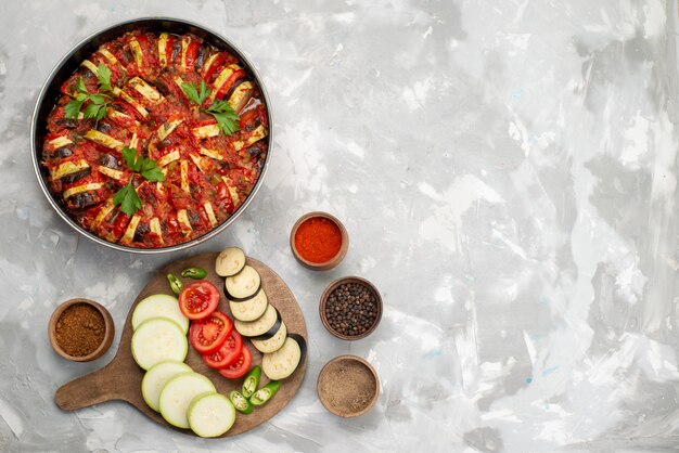 Foto gratuita vista dall'alto di verdure a fette come pomodori e melanzane fresche e cotte sul pasto di cibo verdura fresca matura scrivania bianca