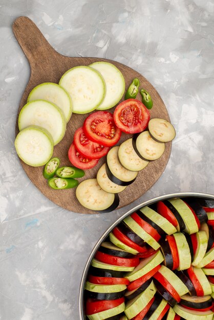 明るい背景に熟した新鮮な野菜食品の食事でトマトやナスなどの野菜をスライスしたトップビュー