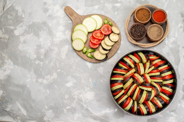 Top view sliced vegetables with seasonings on the light desk vegetable food meal dish fresh