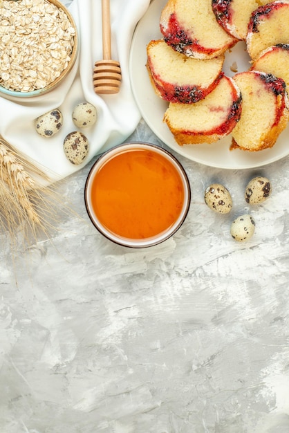 Free photo top view slices of jam cake on plate honey in bowl on table