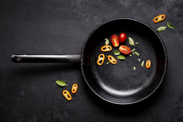 Top view slices of tomatoes and chilli pepper in pan