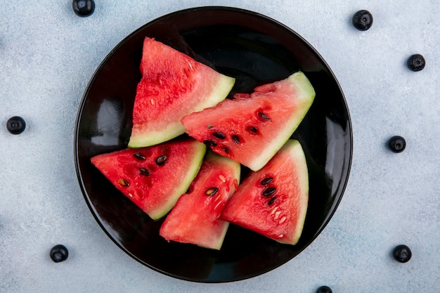 Top view slices of watermelon on a plate with blueberries