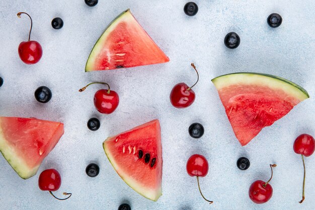 Top view slices of watermelon with cherries and blueberries