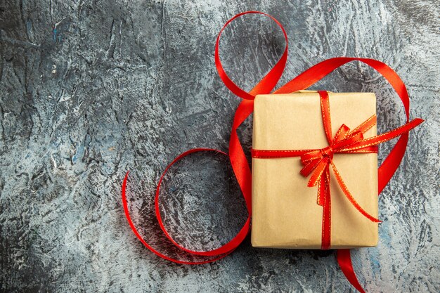 Free photo top view small gift tied with red ribbon on dark isolated background