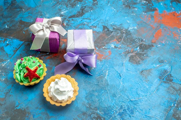 Top view small tarts small gifts on blue red table with copy place