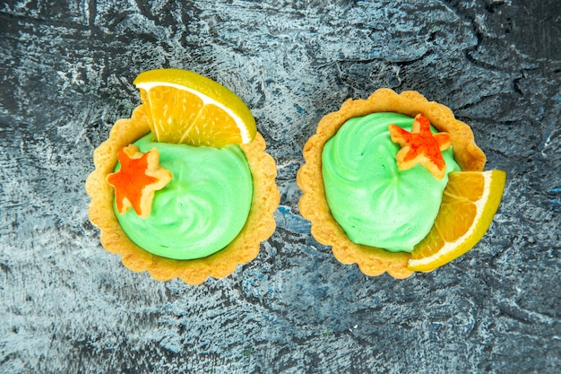 Free photo top view small tarts with green pastry cream on grey table