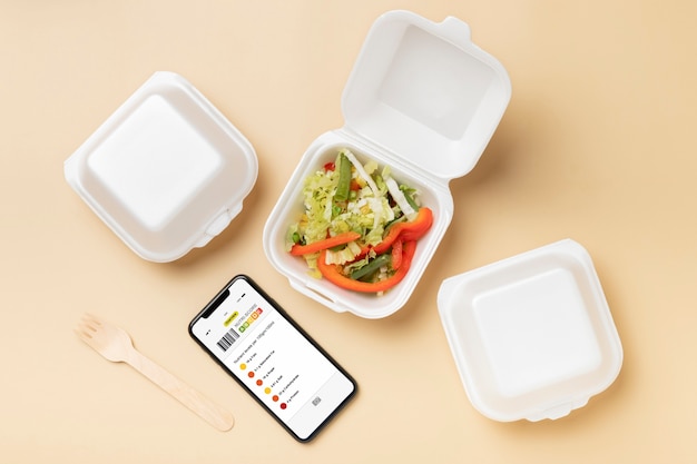 Free photo top view smartphone and food containers