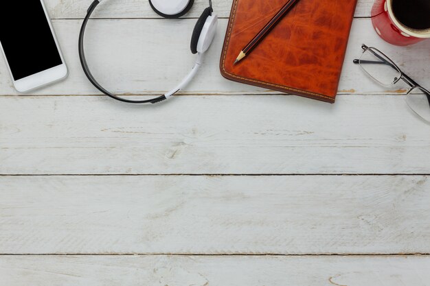 top view smartphone and headphones with coffee cup