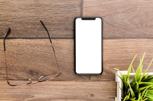 Free photo top view smartphone template over workspace