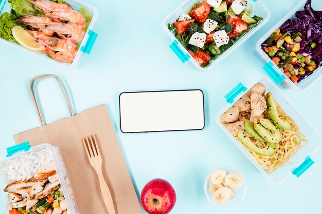 Top view of smartphone with food in casseroles