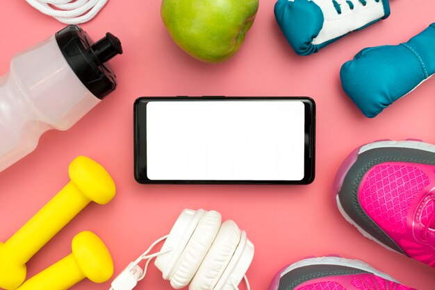 Top view of smartphone with sport essentials