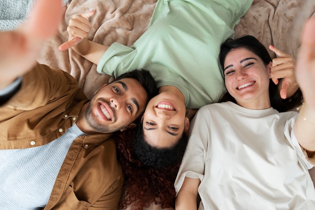 Free photo top view smiley roommates laying together