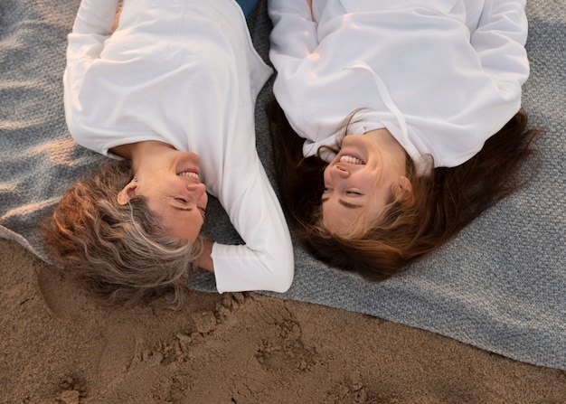 Foto gratuita donne sorridenti vista dall'alto sulla spiaggia