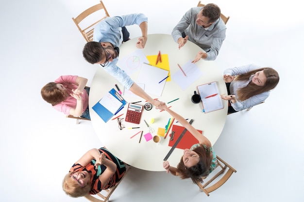 白い背景の上の円卓に座って、smilimgビジネスチームの平面図です。成功するトランザクションの概念