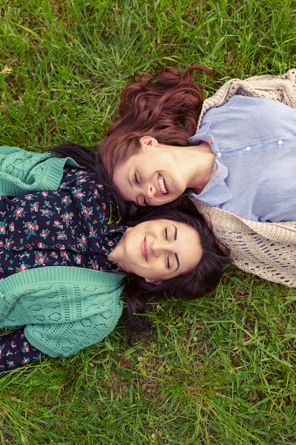 Free photo top view of smiling friends lying on grass having fun