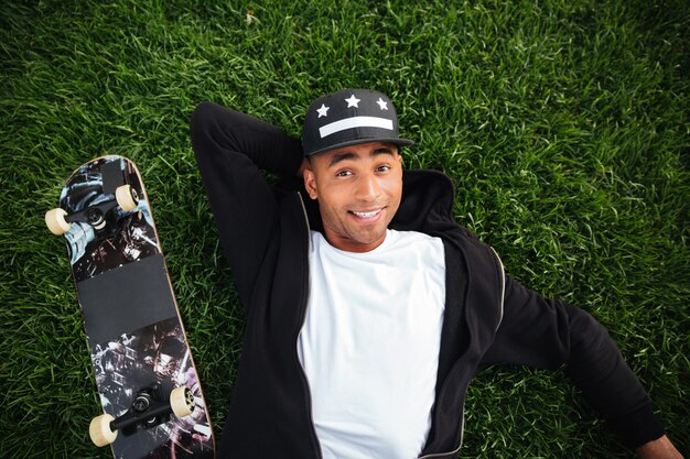 Top view of a smiling happy african male teenager lying