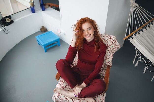 Free photo top view of a smiling happy woman sitting on a chair