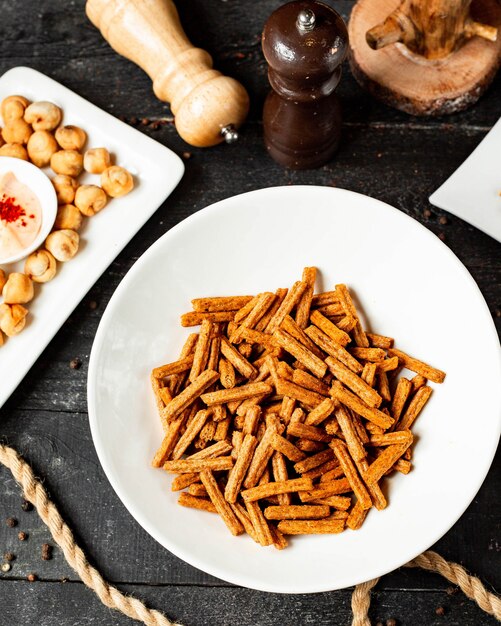 Top view of snack for beer crackers from bread in a plate on black