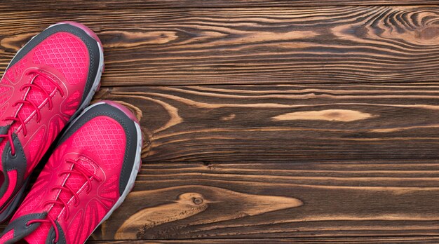 Top view of sneakers on wooden background with copy space