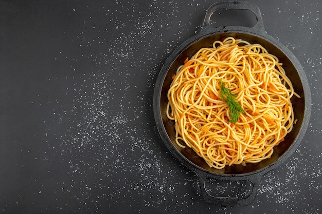 Top view spaghetti frying pan on dark background