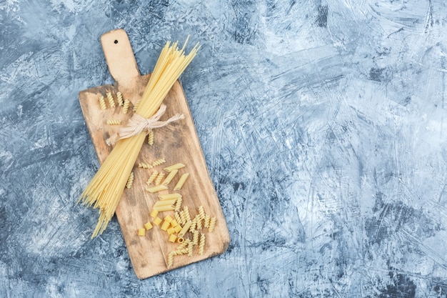 Vista dall'alto spaghetti su intonaco grigio e sfondo tagliere. orizzontale
