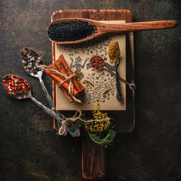 Top view spice with cinnamon and pepper and spoon in wood plate