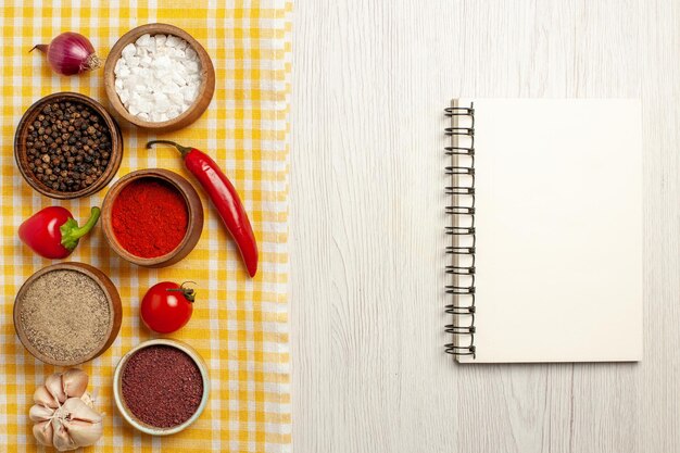 Free photo top view of spicy seasonings with vegetables on white