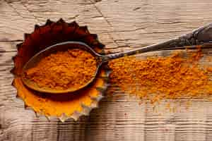 Free photo top view of spoon with cinnamon on wooden surface