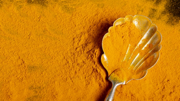 Top view of spoon with turmeric with copy space