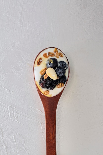 Top view spoon with yogurt and fruits