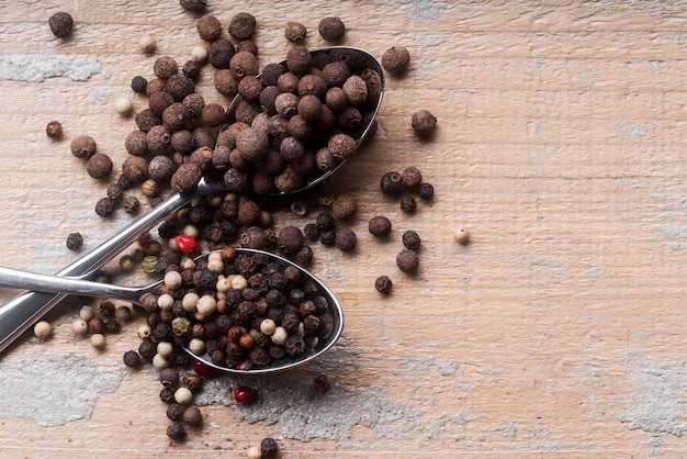 Top view spoons with peppercorns