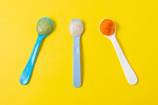 Top view spoons on yellow background