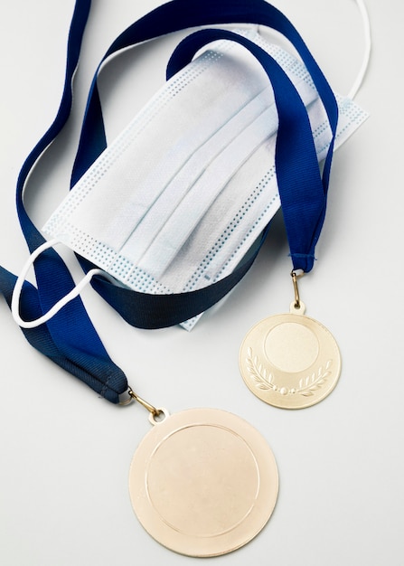Вид сверху спортивная медаль рядом с медицинской маской