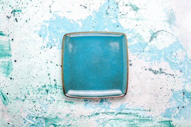 Top view square plate blue colored empty on light blue surface plate glass color food