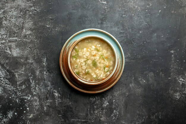 Top view star soup in bowl on dark surface