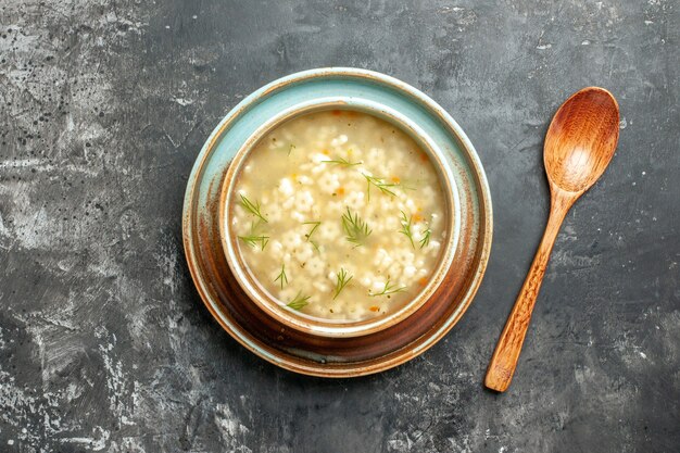 Top view star soup in bowl wooden spoon on dark surface