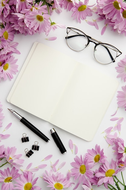 Top view stationary arrangement on desk with notebook and glasses