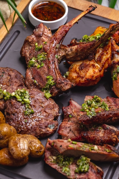 Foto gratuita vista dall'alto bistecca con costine fritte con pollo fritto e patate su una tavola con salsa