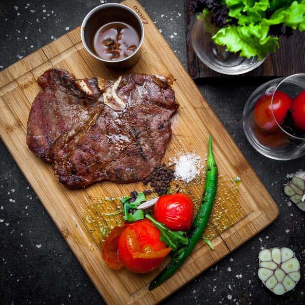 Top view steak with tomato and paper in steak board