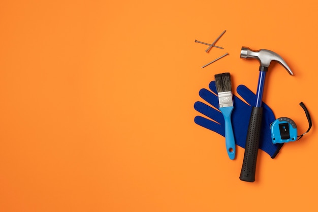 Top view of steel hammer with other construction elements and tools