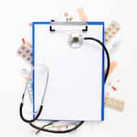 Free photo top view stethoscope with medicine tablets