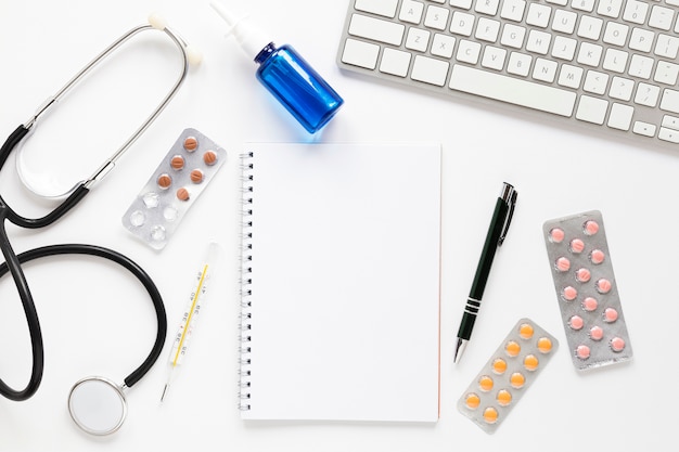 Free photo top view stethoscope with tablets and keyboard